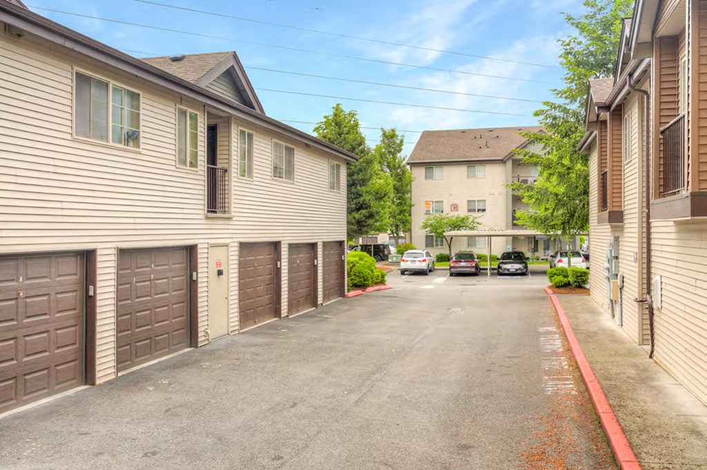 the street in front of a house with garages on both sides of it