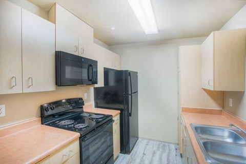 a kitchen with black appliances and white cabinets
