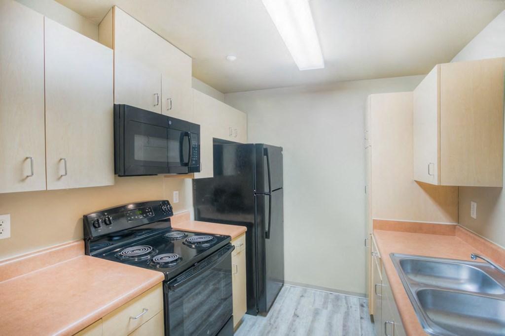 a kitchen with black appliances and white cabinets