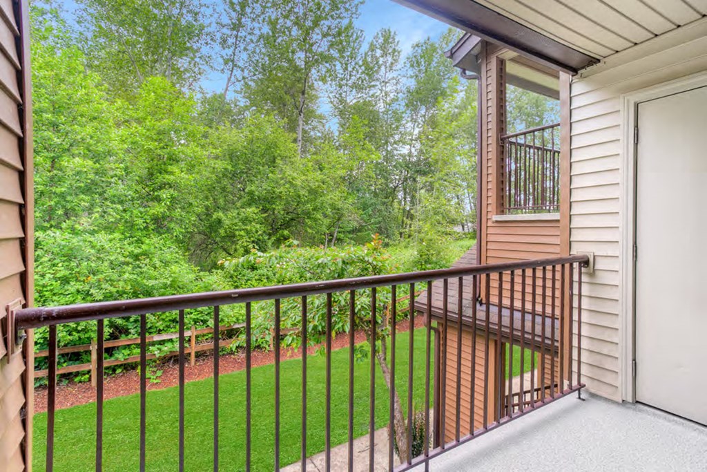a balcony with a view of a yard and trees
