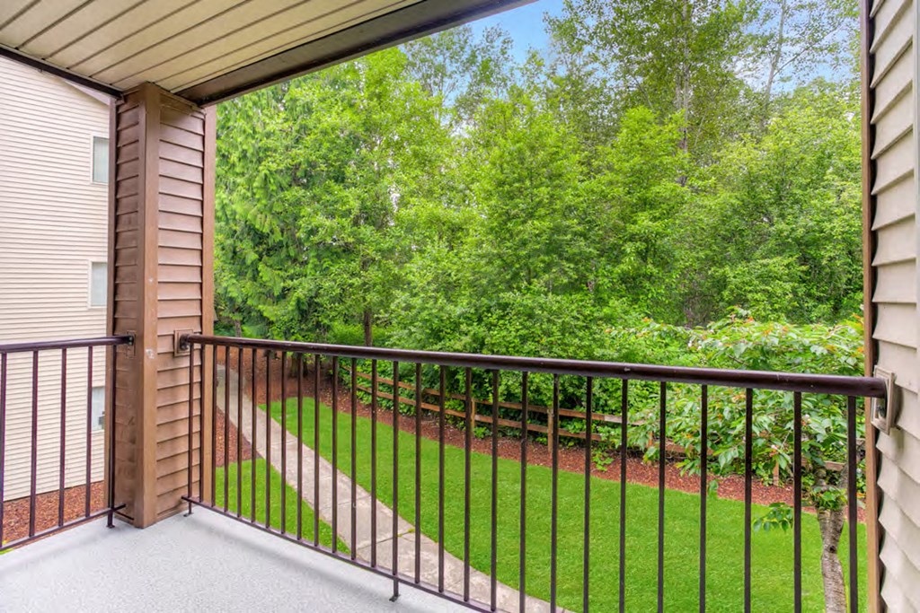 a balcony with a view of a yard and trees