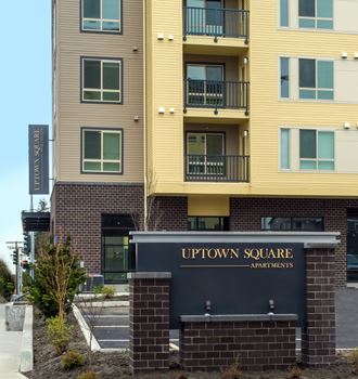 an apartment building with a sign for uptown square apartments