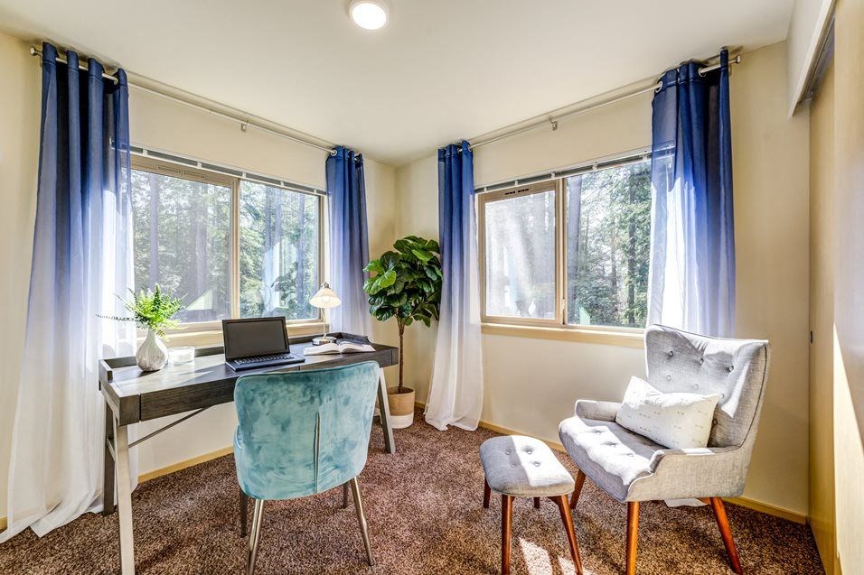 a home office with two chairs and a desk with a laptop