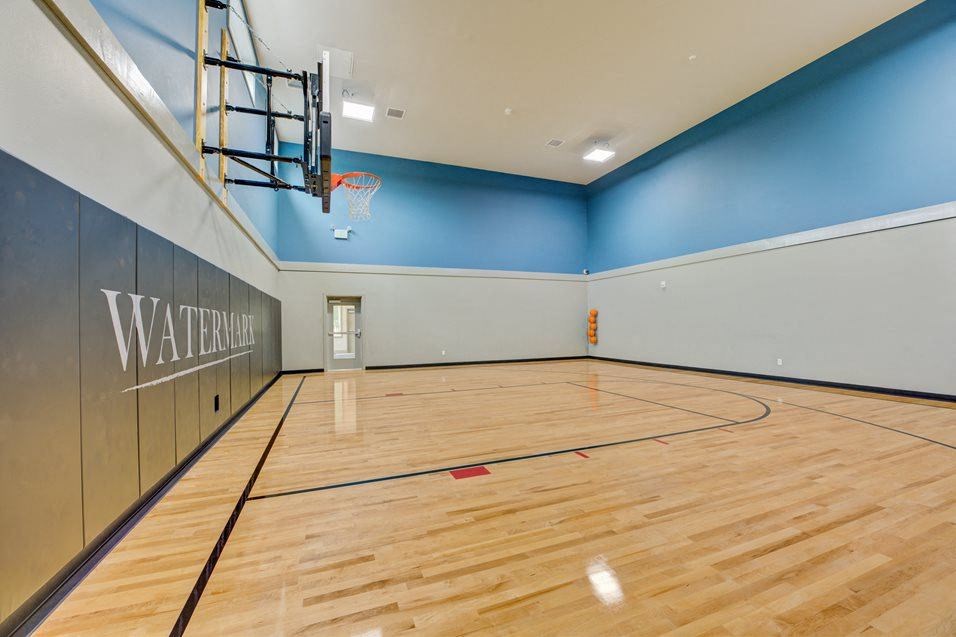 a basketball court in a gym with a basketball hoop