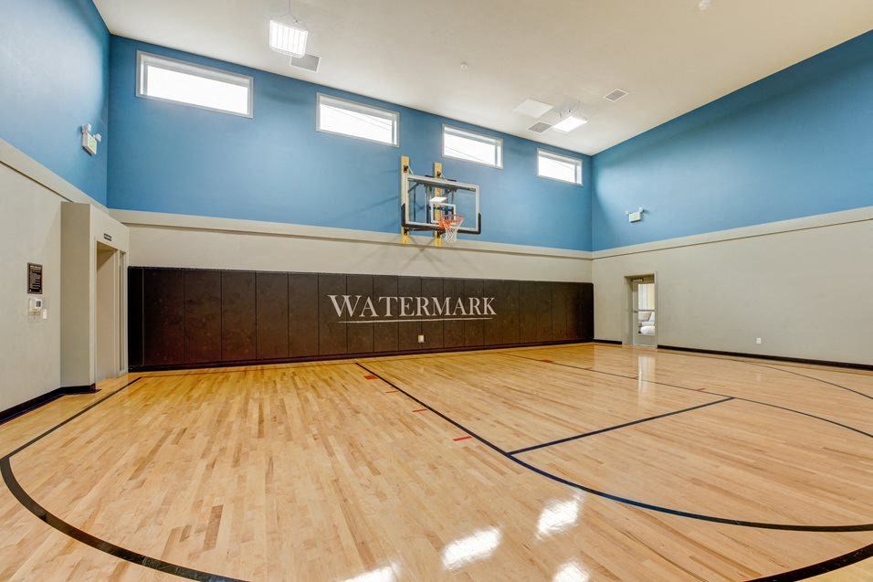 the inside of an empty gym with a basketball court
