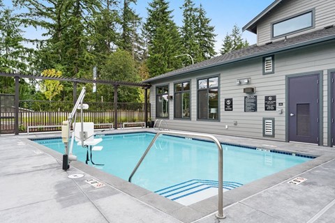 a swimming pool is next to a house with a fence