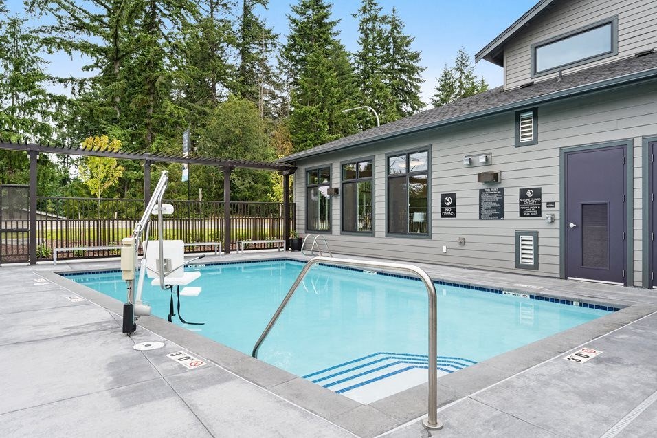 a swimming pool is next to a house with a fence