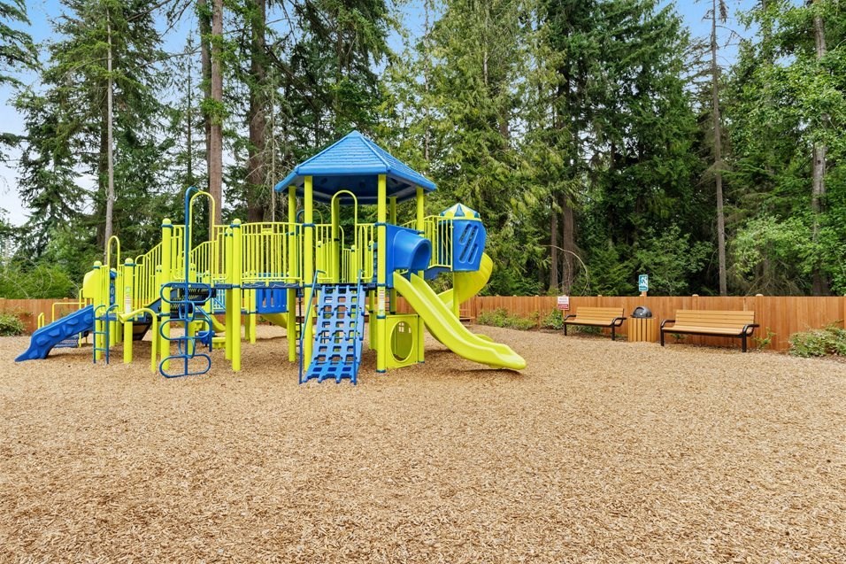 a playground with a blue and yellow swing set