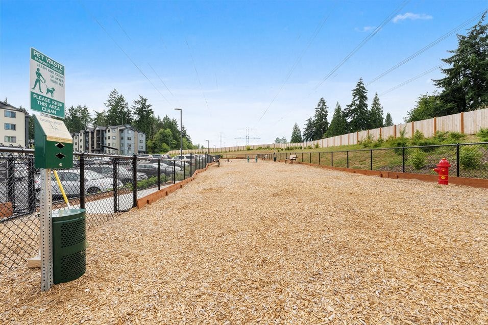 the dog park is fenced in and has a fire hydrant