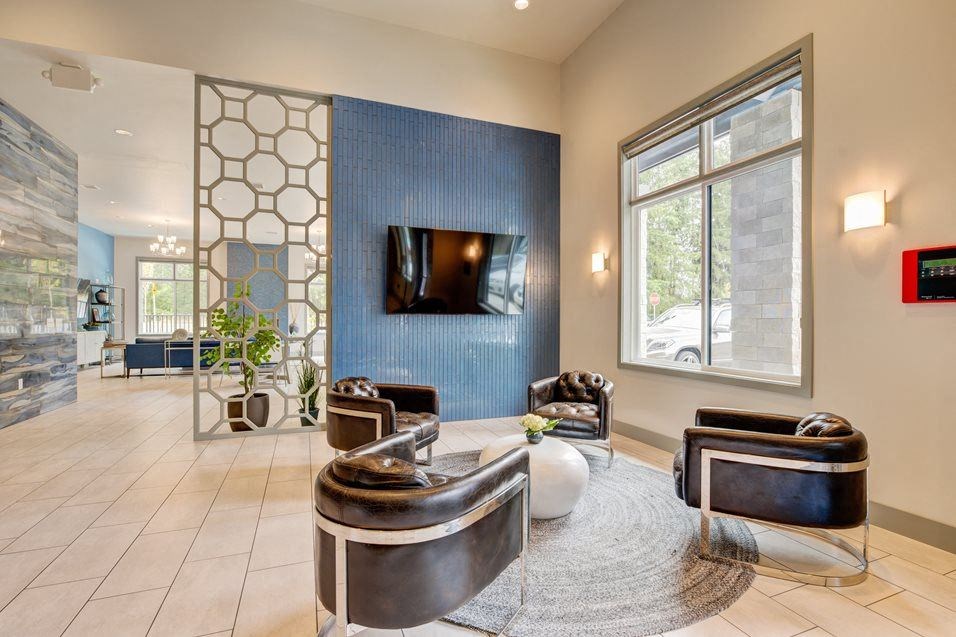 a living room with chairs and a television