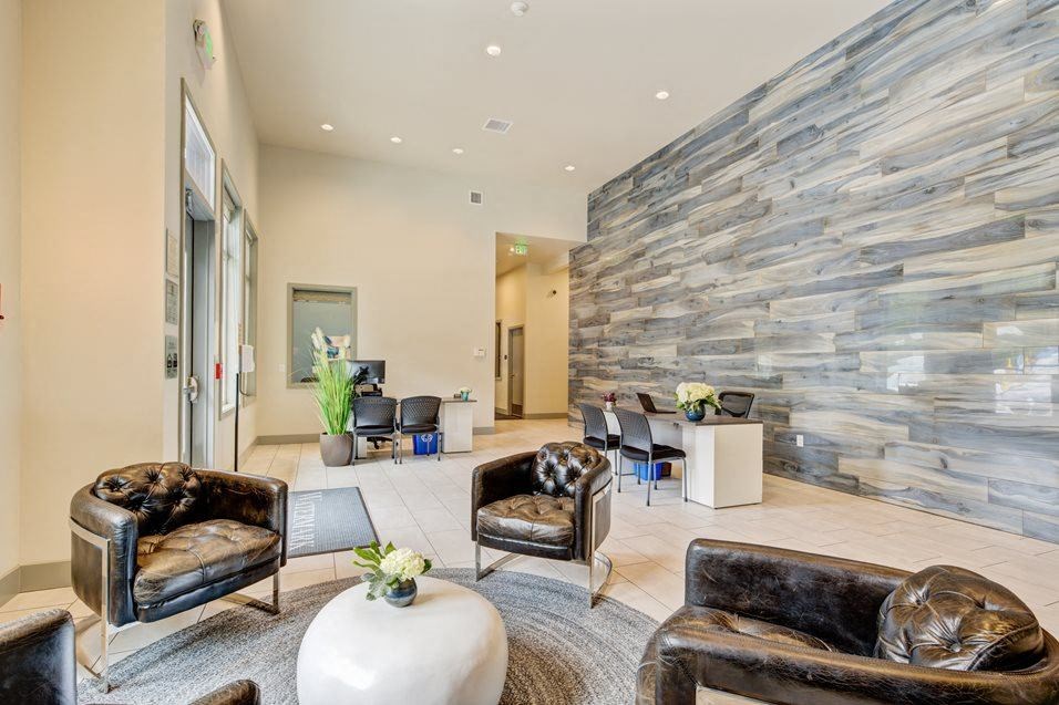 a living room with chairs and a stone wall