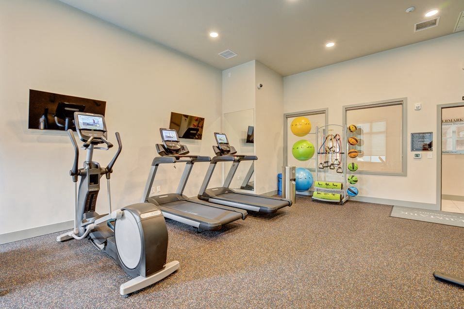 a gym with treadmills and other exercise equipment