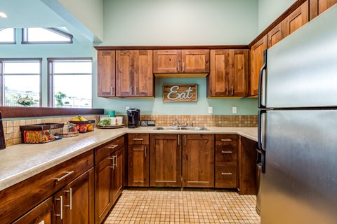 a kitchen with wooden cabinets and a stainless steel refrigerator