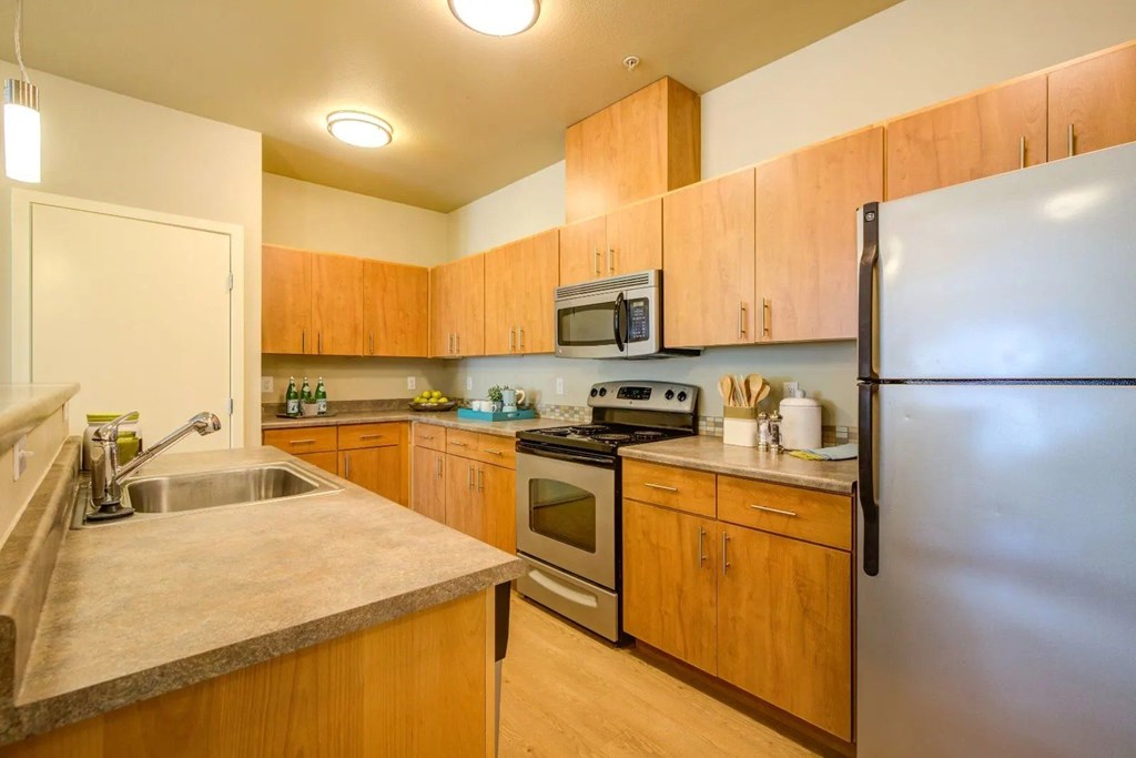 A kitchen with wooden cabinets and a refrigerator.