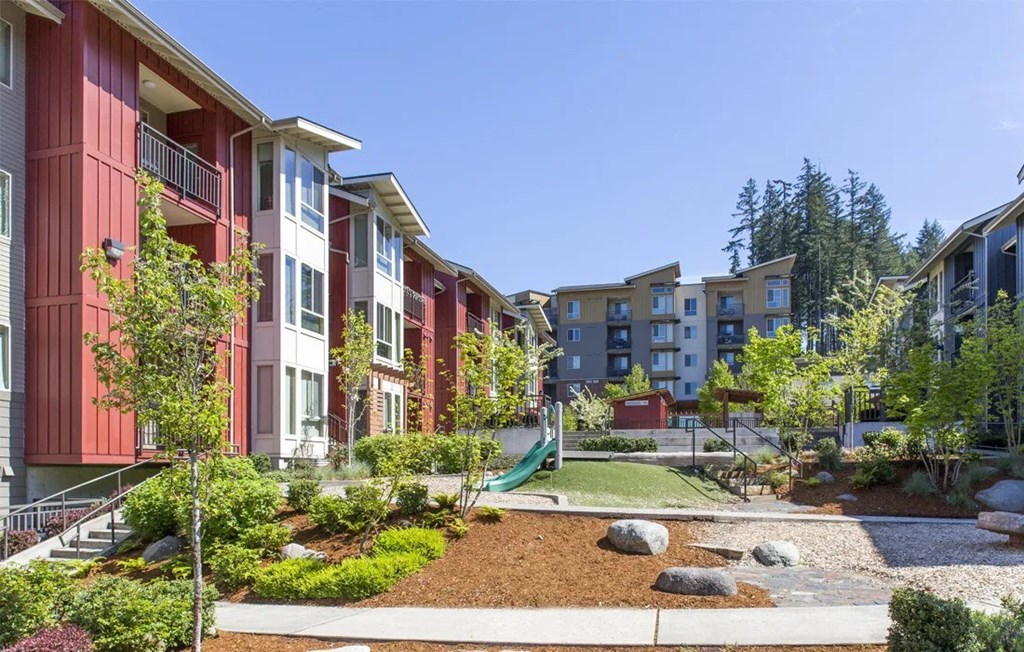 A red building with a green lawn in front.