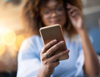 A woman is holding a smartphone in her hand.