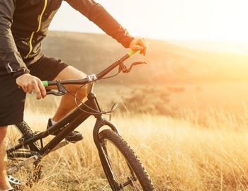 A person is riding a bicycle in a field.
