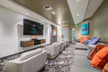 A modern living room with a grey sofa and a television on the wall.
