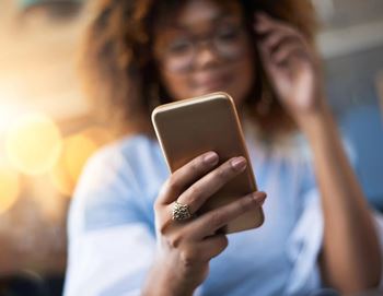 A woman is holding a smartphone in her hands.