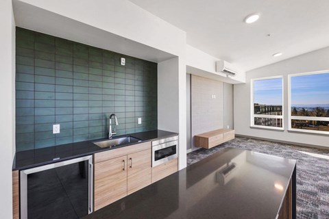 A modern kitchen with a black countertop and wooden cabinets.