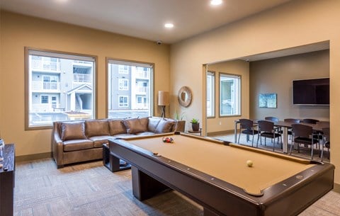 a living room with a pool table and a couch