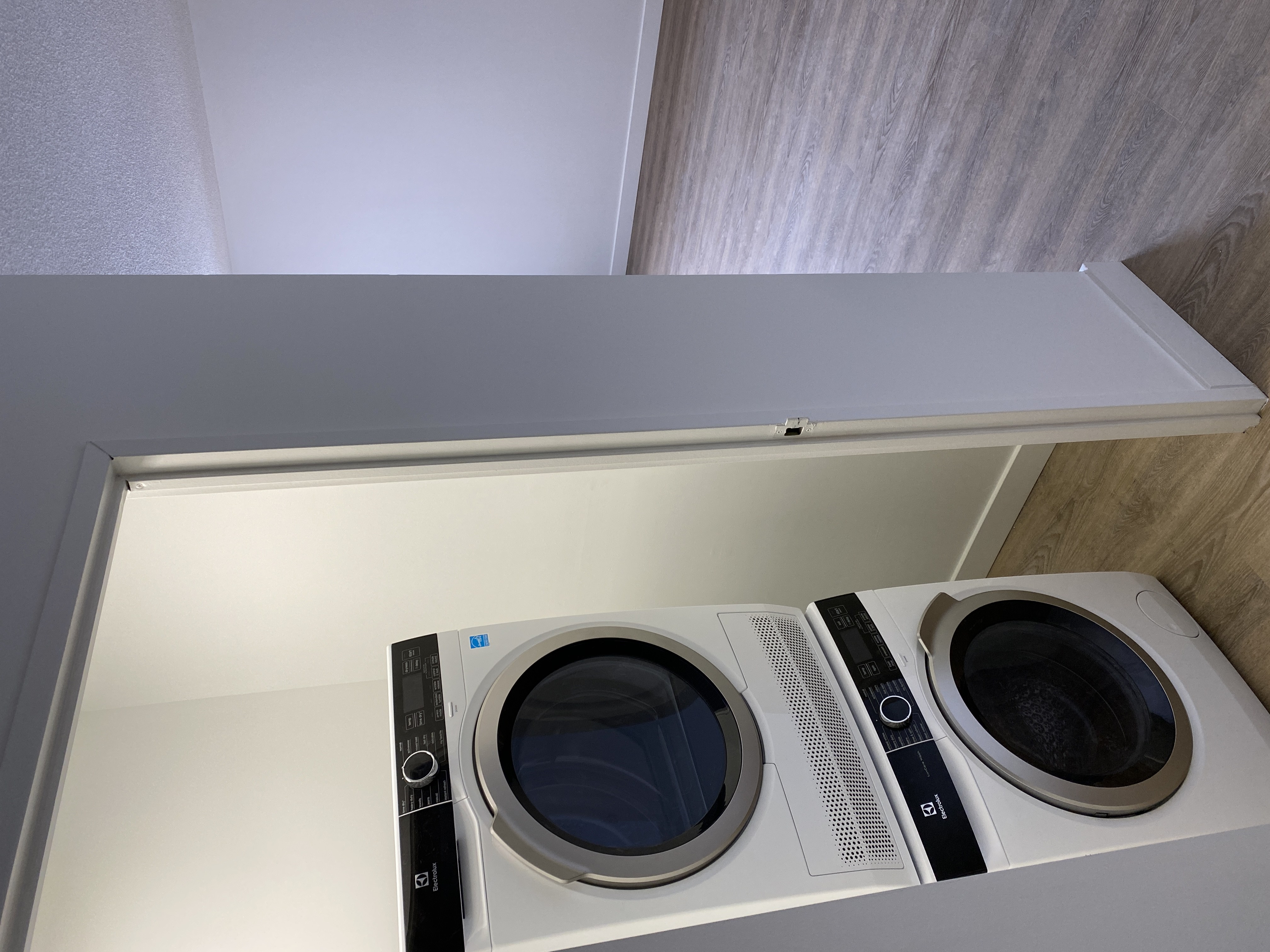 A washing machine is sitting in a cabinet.