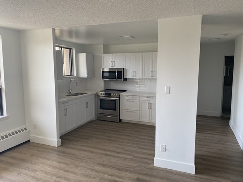 A kitchen with white cabinets and a stainless steel oven.