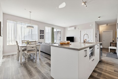A modern kitchen with a dining table and chairs.