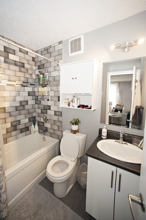 A bathroom with a white toilet, a white sink, and a white bathtub.