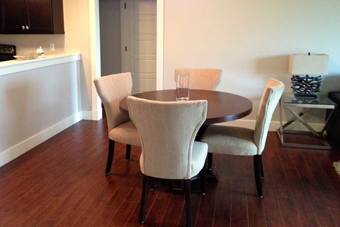 A dining room with a table and chairs.