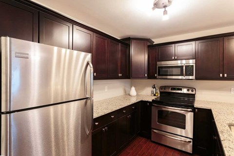 A kitchen with a stainless steel refrigerator and a stainless steel oven.