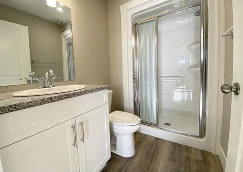 A bathroom with a toilet, sink, and shower.