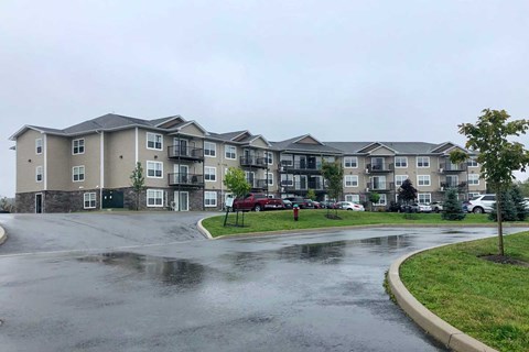 Apartment complex with a wet parking lot in front.