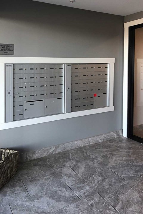 A wall of mailboxes is on the side of a building.