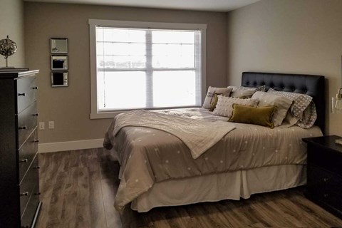 A bedroom with a large bed and a window.