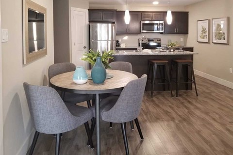 A kitchen with a table and chairs in the foreground.
