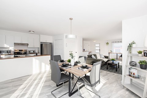 A modern kitchen with a dining table and chairs.