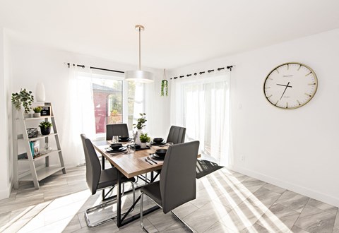 A dining room with a table and chairs.