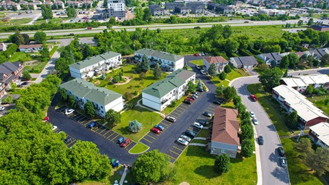 A bird's eye view of a residential area with houses and a parking lot.