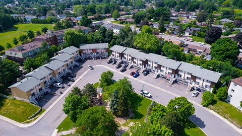 A bird's eye view of a residential area with houses and parked cars.