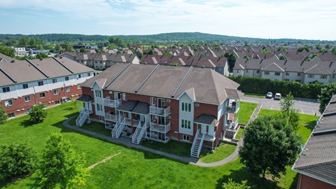 A large red brick house with a white staircase in front.