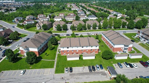 A large red brick building sits in the middle of a green grassy area.