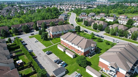 A bird's eye view of a residential area with houses and parked cars.