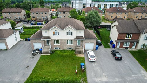 A large house with a driveway and a car parked in front.