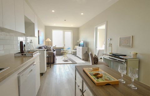 A modern kitchen with a wooden table and a tray of food on it.