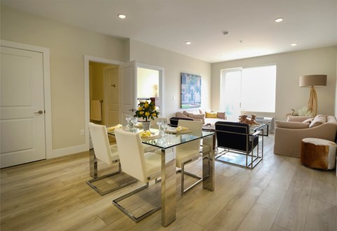 A modern dining room with a glass table and chairs.