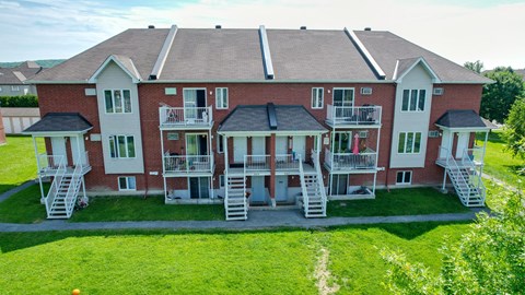 A red brick building with white railings and stairs leading to the entrance.