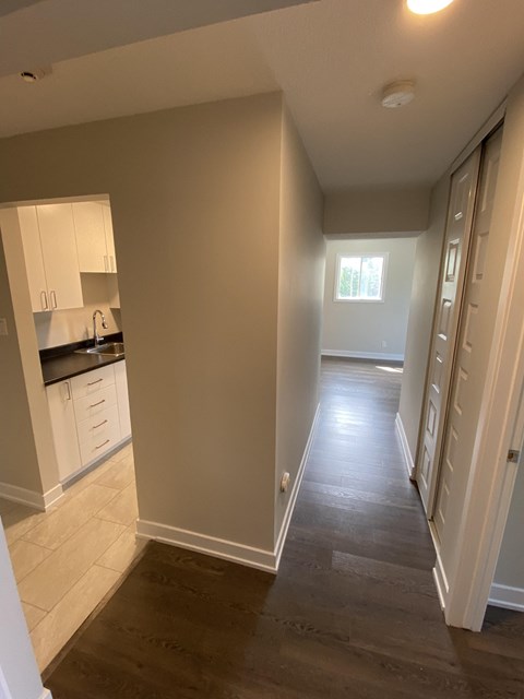 A kitchen with white cabinets and a window.