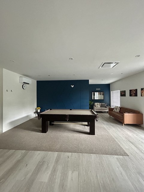 A pool table in a room with a blue wall.