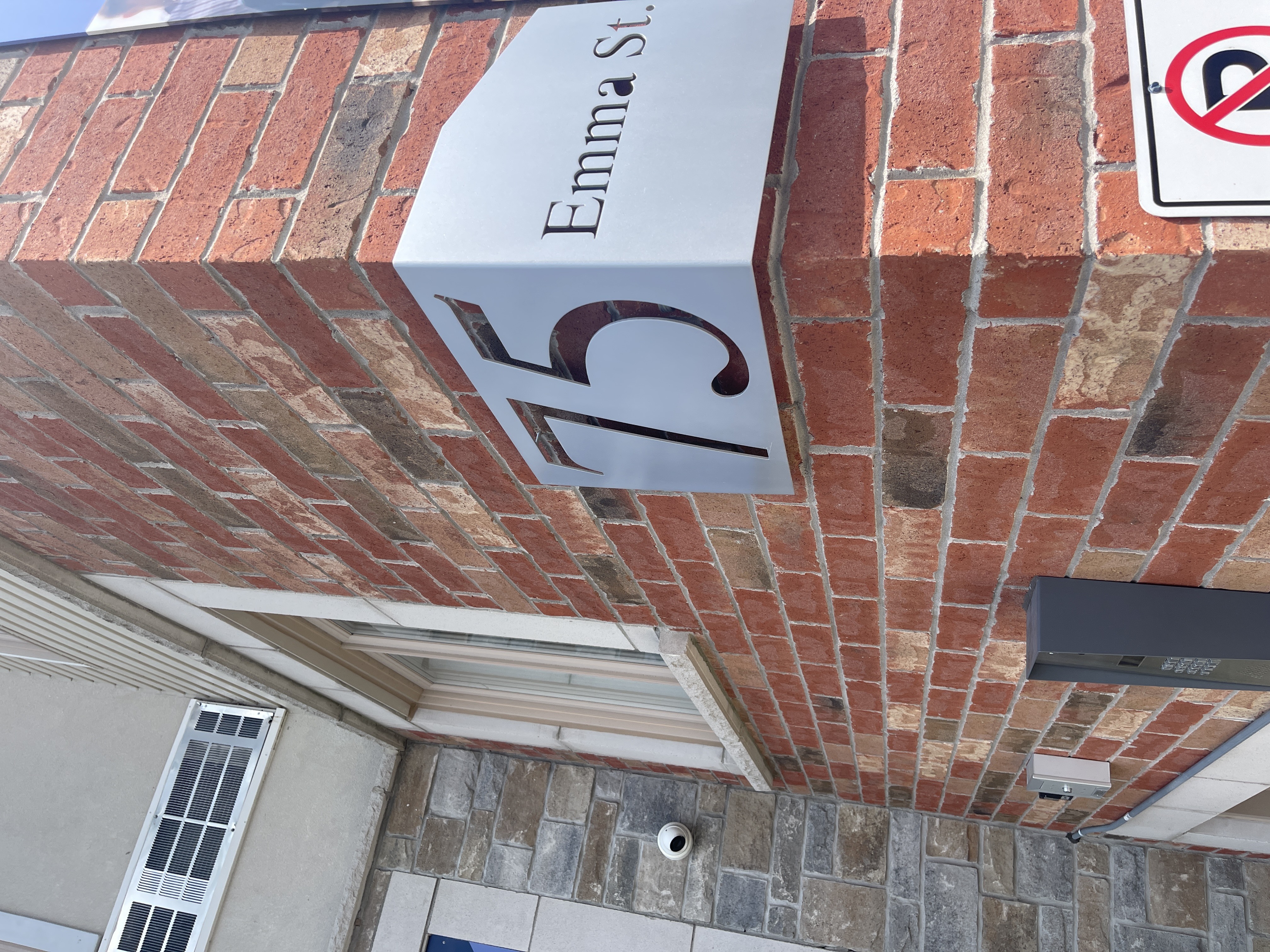 A brick wall with a sign that says Emma St.